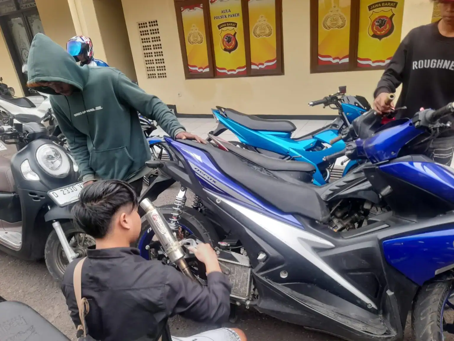 Motor sports Yamaha blue di dekat kendaraan lain di jalan kota Indonesia, suasana ramai.
