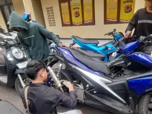 Motor sports Yamaha blue di dekat kendaraan lain di jalan kota Indonesia, suasana ramai.